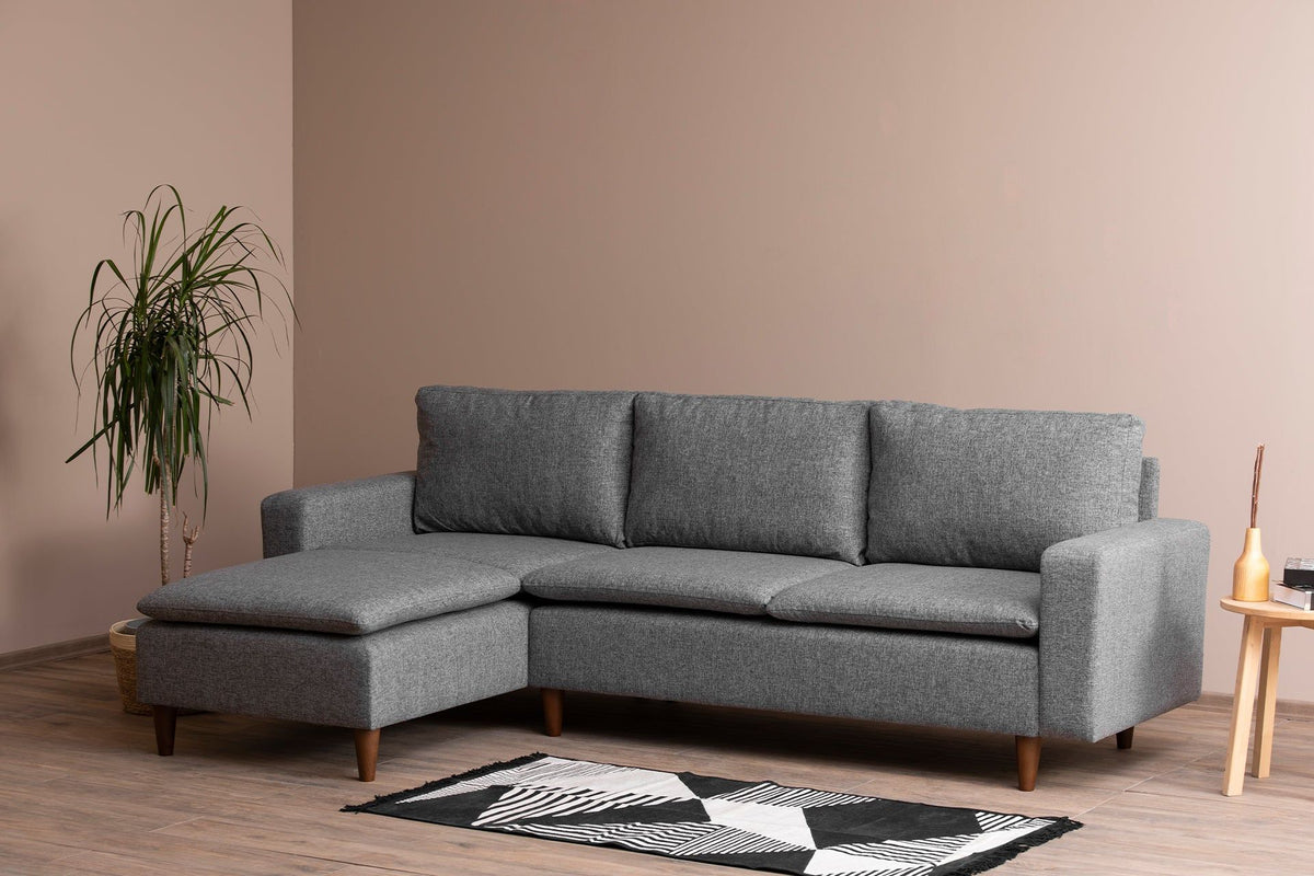 Gray L-shaped modular sectional sofa with chaise and wood legs in a living room